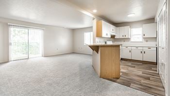 A spacious kitchen with white cabinets and a wooden island